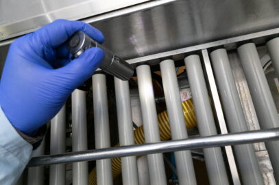 Pracownik kontroli jakości w zakładzie spożywczym sprawdza dokładność wykonania mycia maszyny produkcyjnej