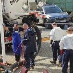 Pracownicy spółki Climbex w odzieży roboczej i ładowarka próżniowa przed Urzędem Miasta w Lądku Zdroju po powodzi