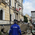 Pracownik operacyjny spółki Climbex w odzieży roboczej przed Urzędem Miasta w Lądku Zdroju po powodzi