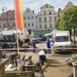 Pracownicy spółki Climbex w odzieży roboczej i ładowarka próżniowa przed Urzędem Miasta w Lądku Zdroju po powodzi